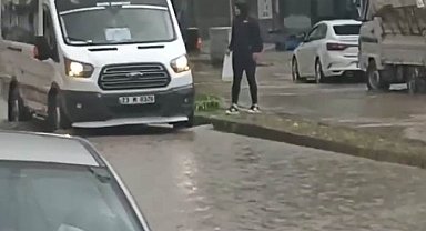Dolmuş şoförü yağmur sularının ortasında kalan yolcuyu inip şoför kapısından içeri aldı