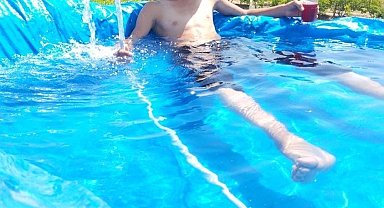 Sıcaktan bunalan çocuklardan ilginç serinleme yöntemi: Toprağı kazıp brandadan havuz yaptılar